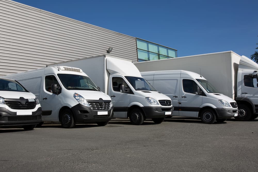 several white vans parked in front of an office building